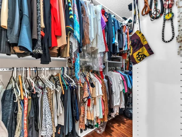 a view of walk in closet with clothes