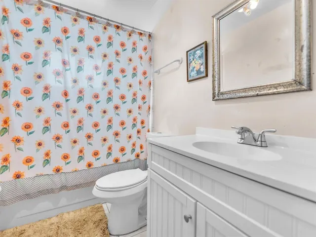 a bathroom with a granite countertop toilet a sink and a mirror