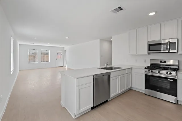 a kitchen with stainless steel appliances granite countertop a stove and a sink