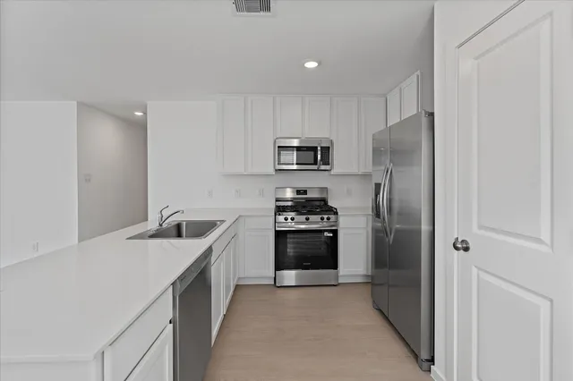 a kitchen with stainless steel appliances a refrigerator stove and sink