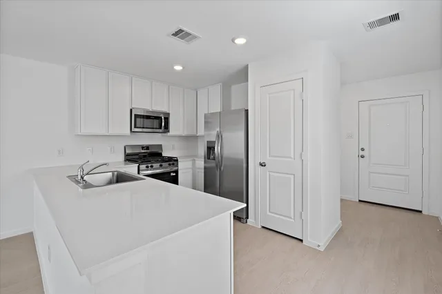 a kitchen with a refrigerator a stove top oven a sink and dishwasher