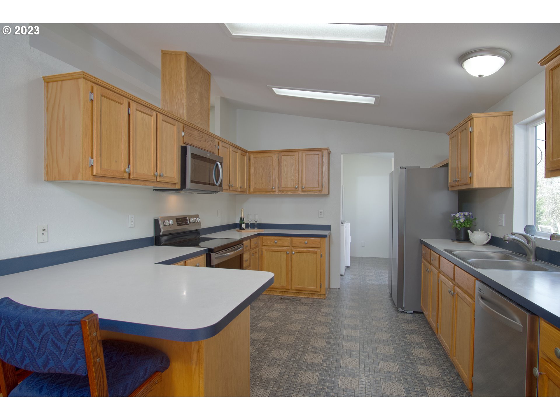 18950 South Ridge Road Oregon City, OR 97045 - Photo 9 of 27 a kitchen with stainless steel appliances a sink a stove a refrigerator cabinets and a counter top space
