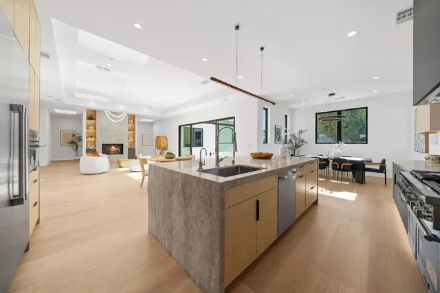 a kitchen with stainless steel appliances granite countertop a sink stove and refrigerator