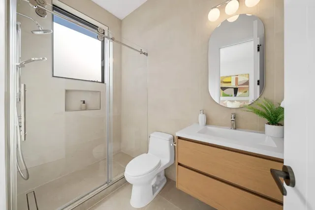 a bathroom with a granite countertop sink a toilet and mirror