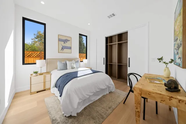 a spacious bedroom with a bed and chandelier