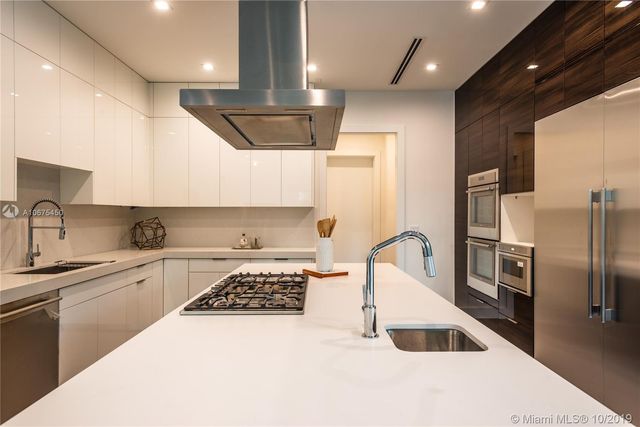 a kitchen with stainless steel appliances a sink a stove a refrigerator and cabinets