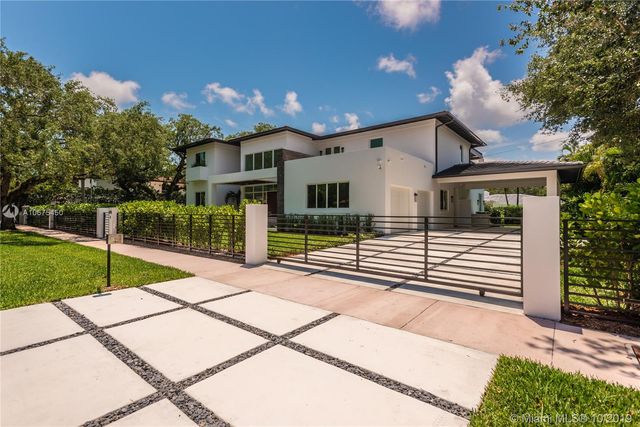 a view of a house with backyard and a tree