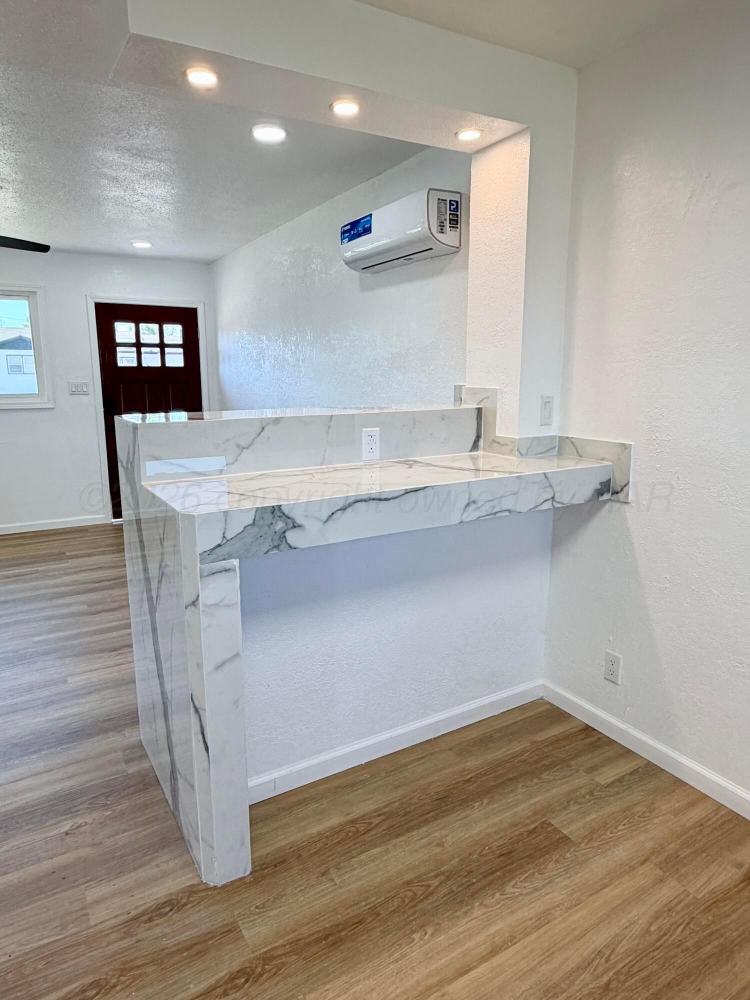 104 Warwick Street Borger, TX 79007 - Photo 12 of 28 a view of a kitchen cabinets a sink wooden floor and a living room