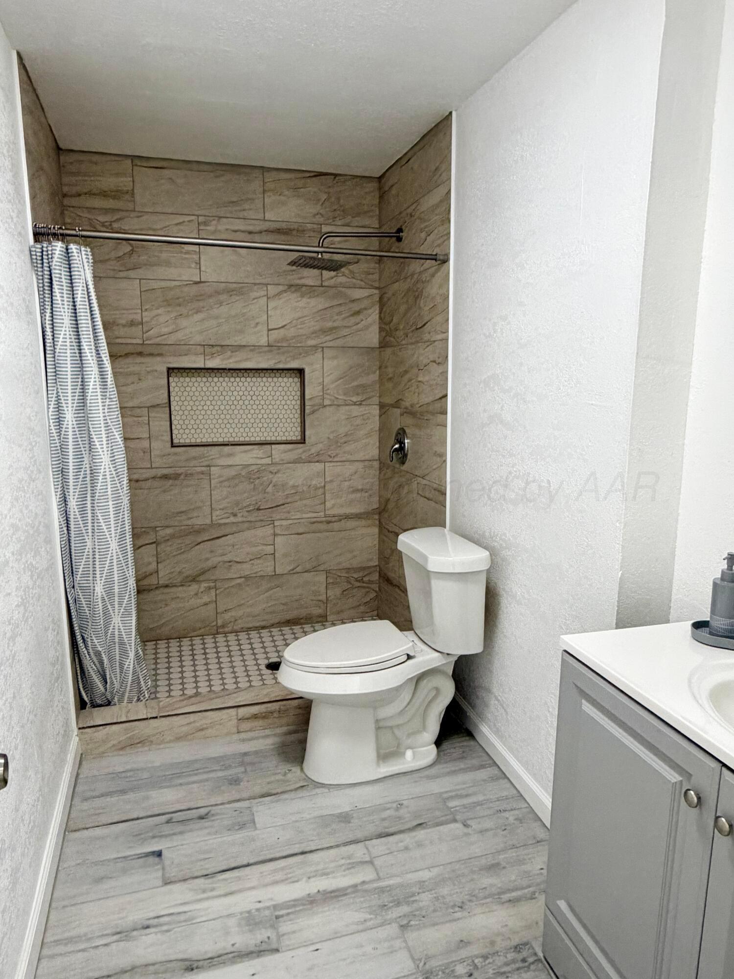 104 Warwick Street Borger, TX 79007 - Photo 17 of 28 a bathroom with a toilet and a shower