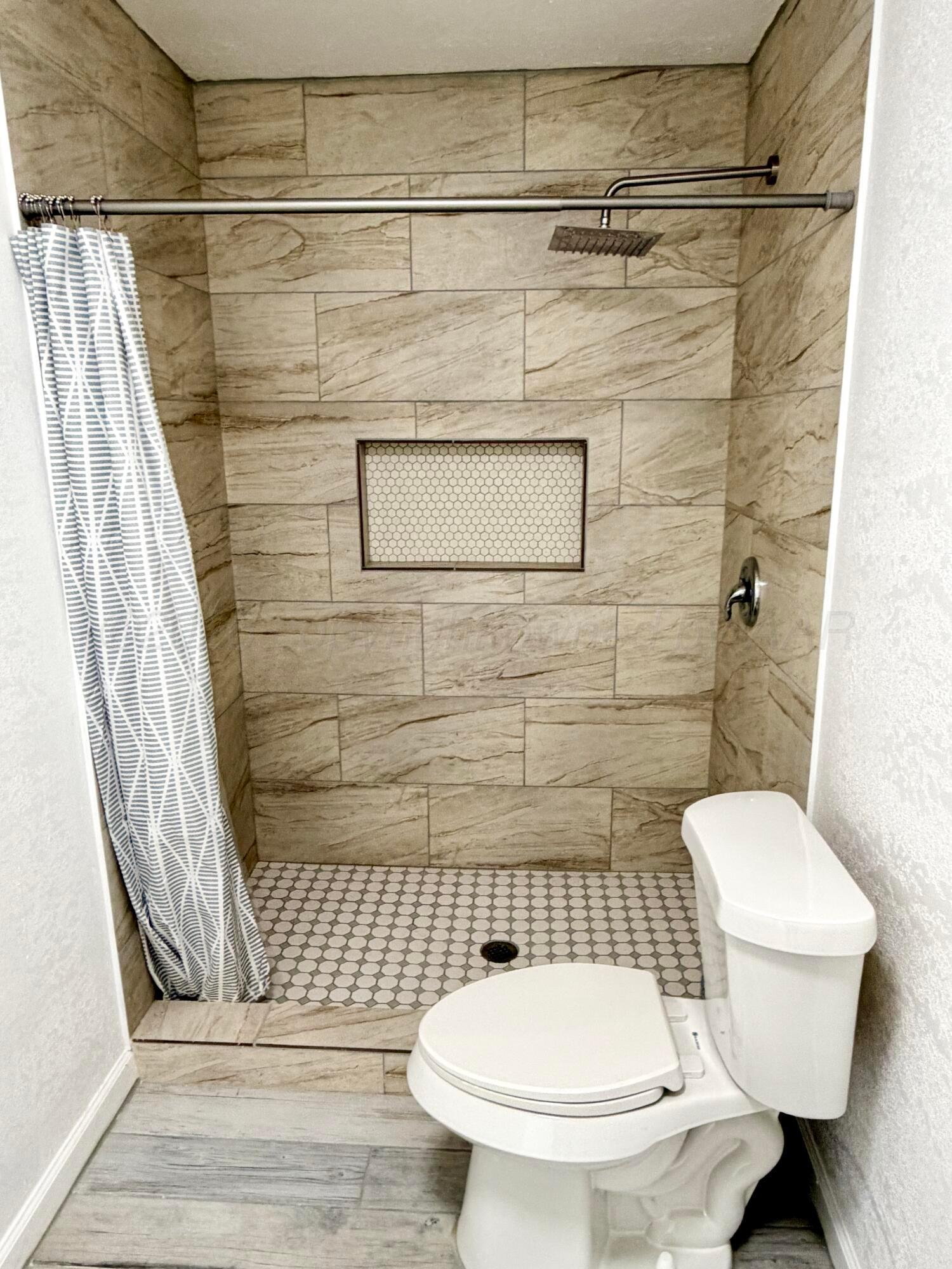 104 Warwick Street Borger, TX 79007 - Photo 20 of 28 a bathroom with a toilet and a shower
