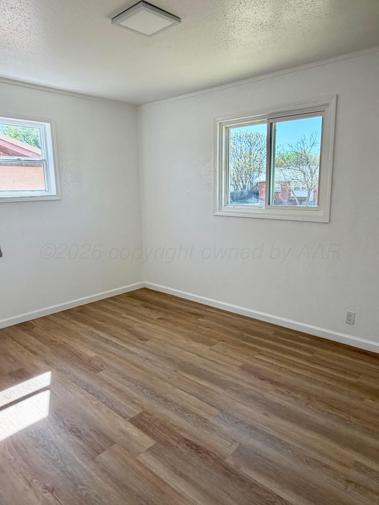104 Warwick Street Borger, TX 79007 - Photo 22 of 28 a view of an empty room with wooden floor and a window