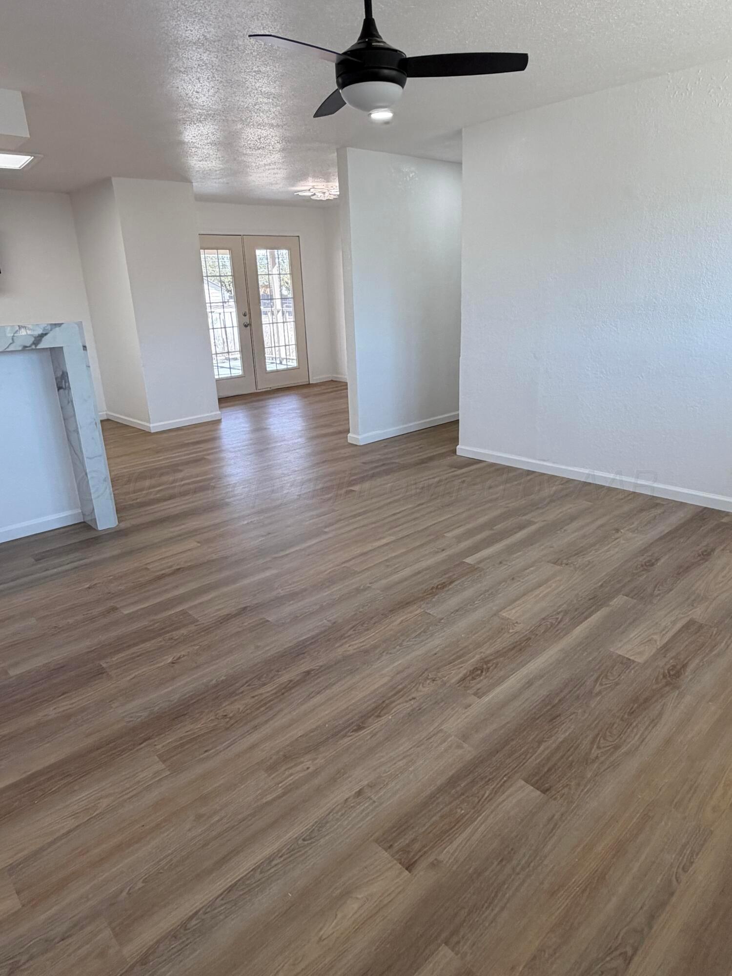 104 Warwick Street Borger, TX 79007 - Photo 6 of 28 wooden floor in an empty room with a window