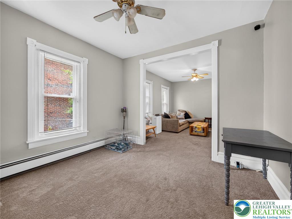 425 Ridge Street Emmaus, PA 18049 - Photo 6 of 27 A well-lit sitting room with plush carpeting, offering a seamless flow into an adjoining living space.