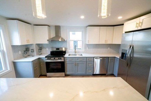 35 Wright Street Stoneham, MA 02180 - Photo 4 of 19 a kitchen with stainless steel appliances granite countertop a stove a sink and a refrigerator