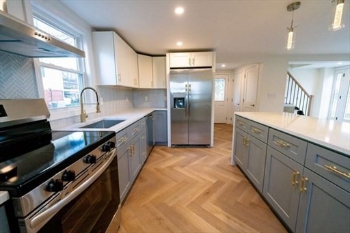 35 Wright Street Stoneham, MA 02180 - Photo 5 of 19 a large kitchen with stainless steel appliances granite countertop a lot of counter space and a sink
