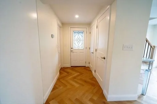 a view of a hallway with wooden floor and staircase