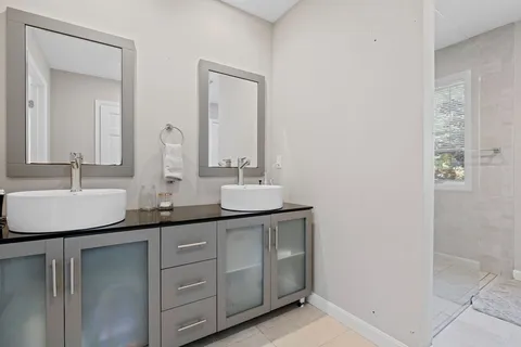 a bathroom with a double vanity sink and a mirror
