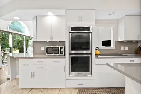 a kitchen with stainless steel appliances a stove a microwave a sink and cabinets