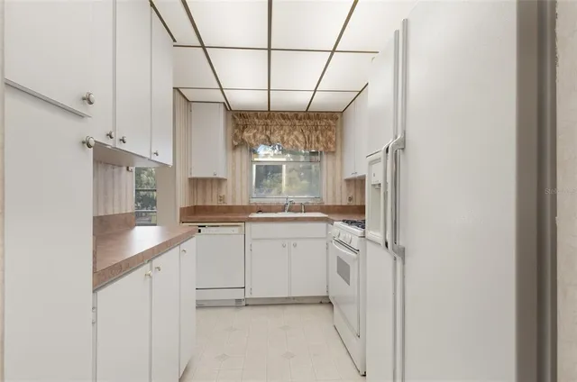 a kitchen with stainless steel appliances granite countertop a sink and a refrigerator