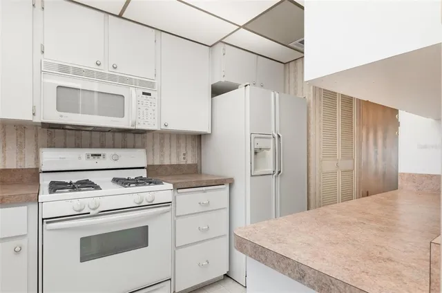 a kitchen with cabinets appliances and wooden cabinets
