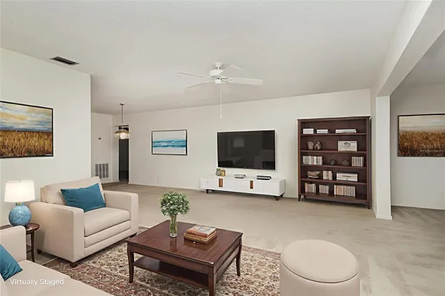 a living room with furniture a window and a flat screen tv