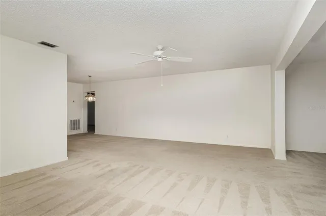 an empty room with an entryway and fan