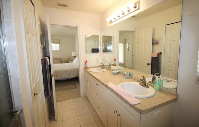 a en suite bathroom with a double vanity sink and a mirror