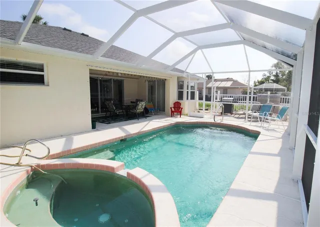 a swimming pool with outdoor seating and yard