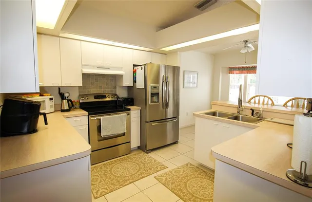a kitchen with a sink appliances and cabinets