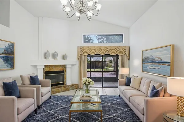 a living room with furniture a chandelier and a fireplace