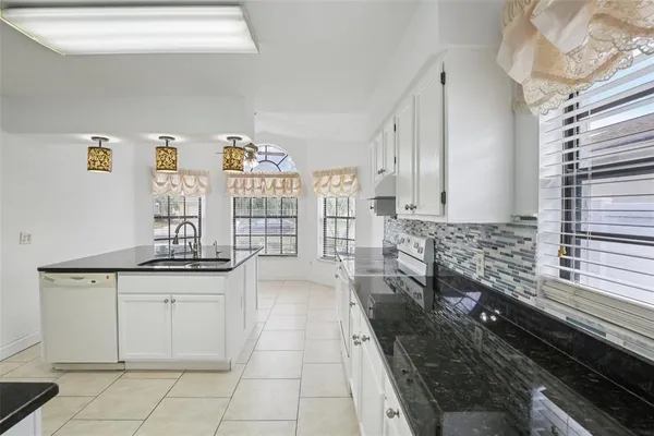 a kitchen with granite countertop a sink and cabinets