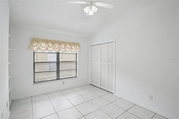 an empty room with windows and cabinet