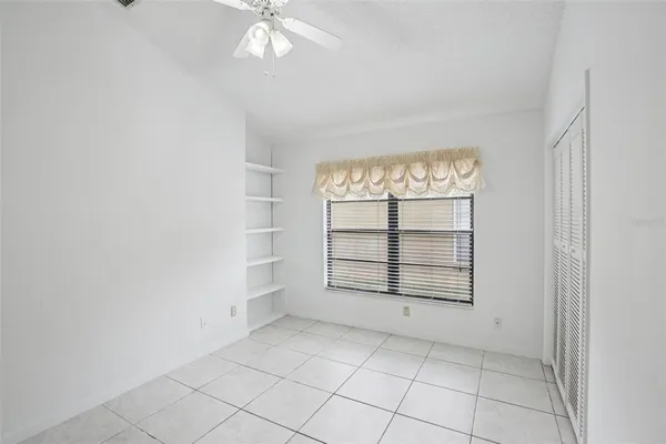 an empty room with windows and cabinet