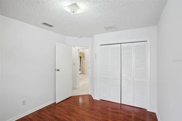 a view of an empty room with wooden floor