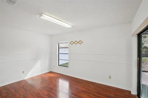 a view of empty room with wooden floor