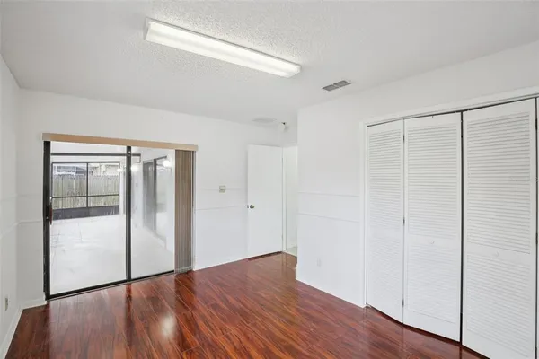 a view of an empty room with wooden floor