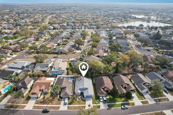 an aerial view of residential houses with outdoor space and trees