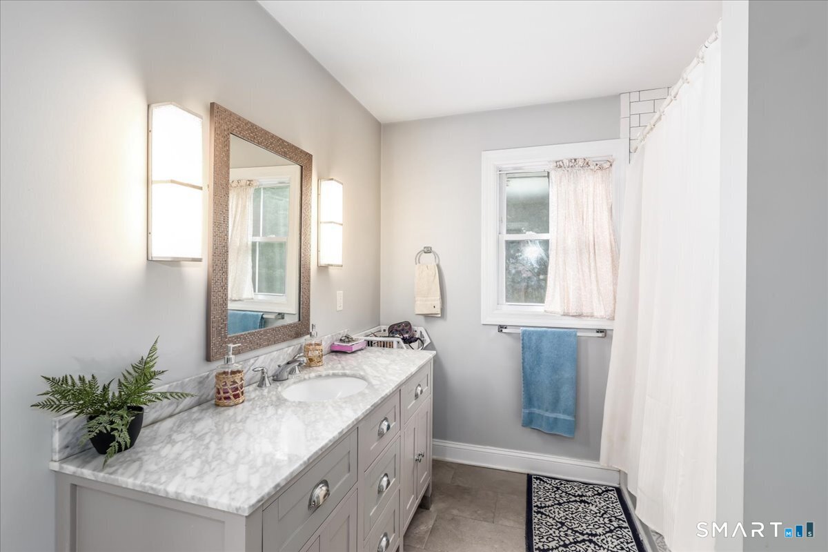 127 Putnam Park Road Bethel, CT 06801 - Photo 17 of 35 a bathroom with a granite countertop sink and a mirror