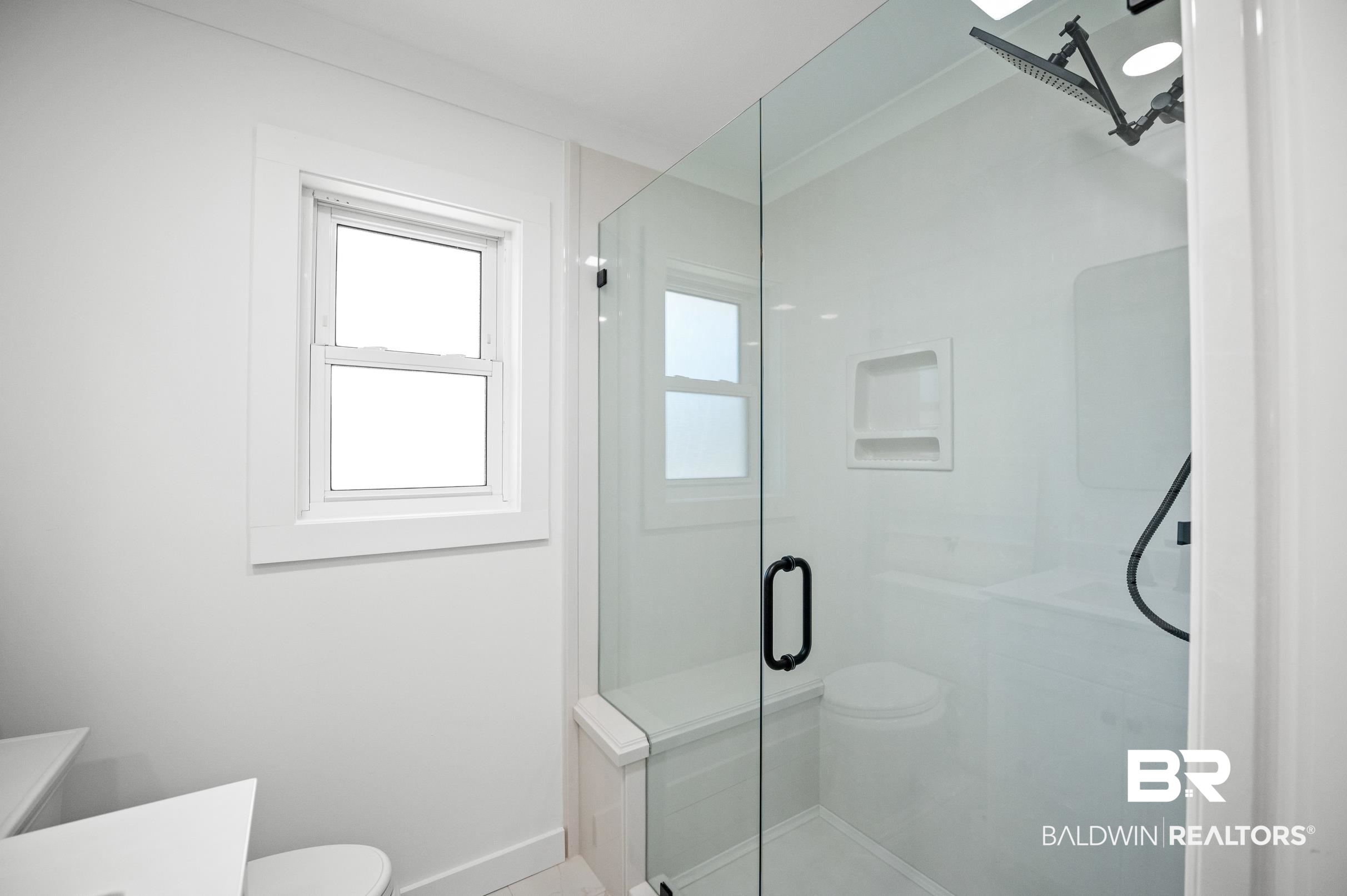 9459 Soldier Creek Road Lillian, AL 36549 - Photo 24 of 54 Bathroom with a stall shower, vanity, toilet, and baseboards