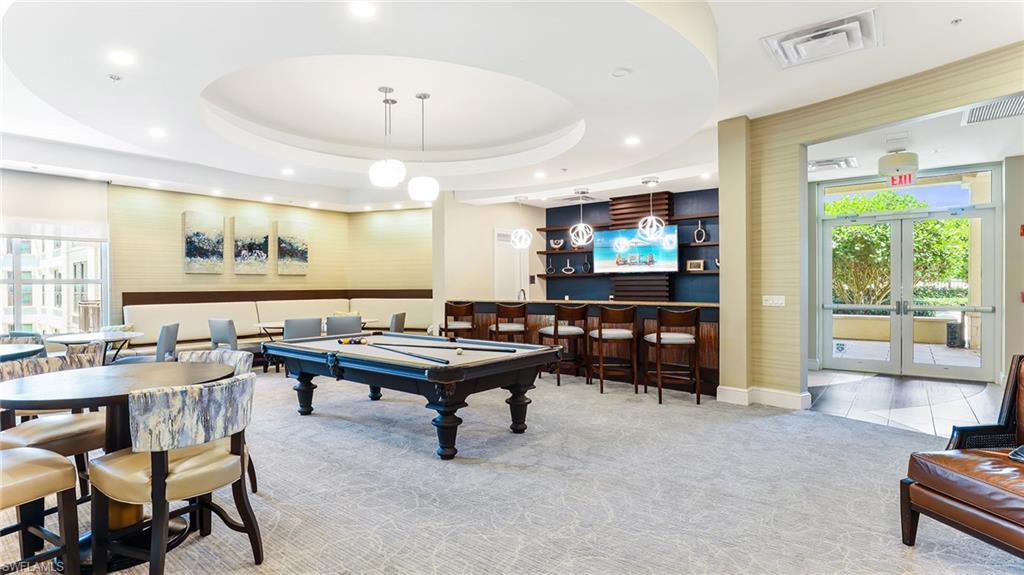 9123 Strada Place, Unit 7409 Naples, FL 34108 - Photo 30 of 34 a living room with furniture a flat screen tv and a large window