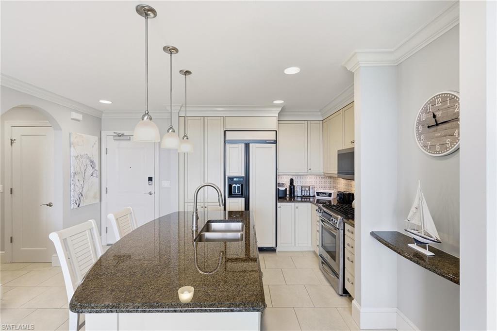 9123 Strada Place, Unit 7409 Naples, FL 34108 - Photo 7 of 34 a kitchen with stainless steel appliances granite countertop a refrigerator a sink a stove and a refrigerator