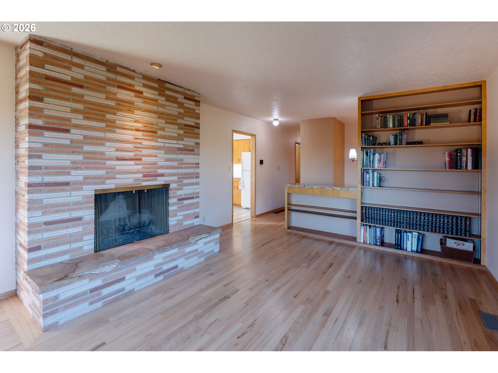 14285 Southwest 114th Avenue Tigard, OR 97224 - Photo 8 of 42 a view of an empty room with wooden floor and a fireplace