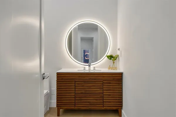 a kitchen with stainless steel appliances a stove a sink a oven a dining table and chairs with wooden floor