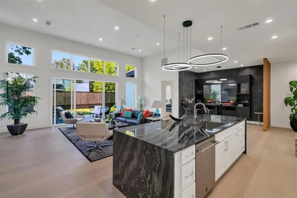 a large kitchen with stainless steel appliances kitchen island granite countertop a large stove top oven and cabinets