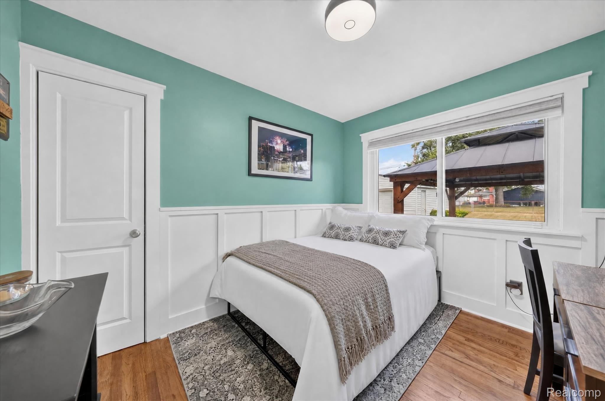 4112 Durham Road Royal Oak, MI 48073 - Photo 15 of 38 Wood-finish flooring, white paneled wall detailing, wide window trim, and a built-in overhead light fixture