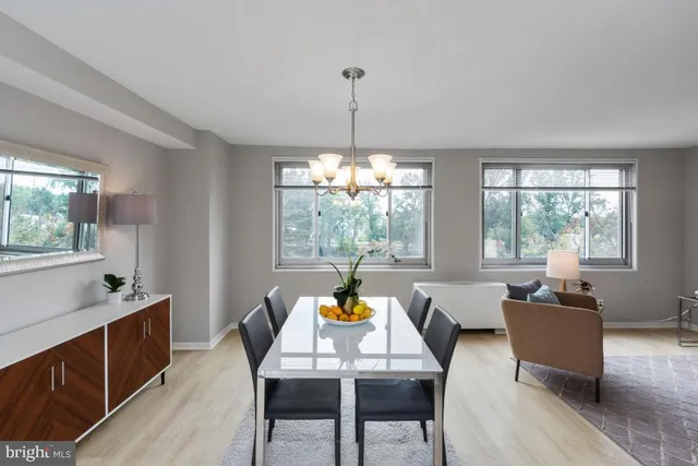 a dining room with furniture a chandelier and wooden floor