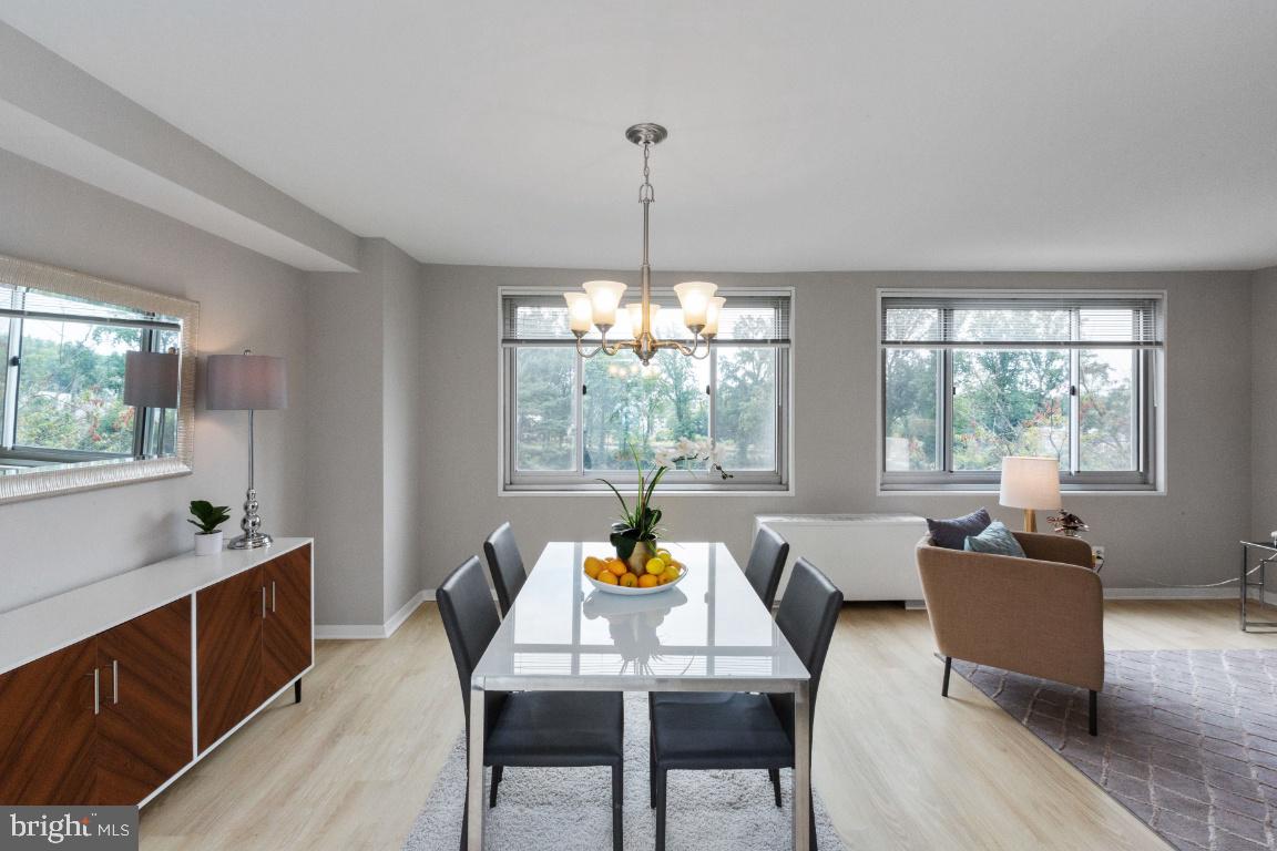 1900 Lyttonsville Road, Unit 714 Silver Spring, MD 20910 - Photo 5 of 22 a dining room with furniture a chandelier and wooden floor