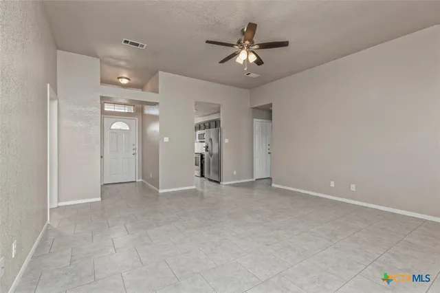 wooden view of an empty room with a chandelier fan