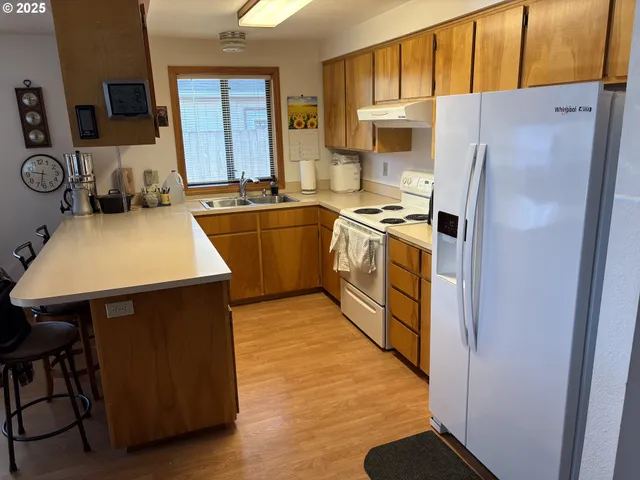 a kitchen with stainless steel appliances a stove a refrigerator sink and white cabinets