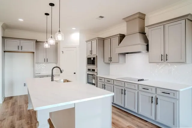 a kitchen with stainless steel appliances a sink a stove a refrigerator and cabinets